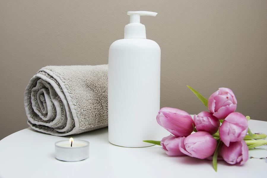 Spa towels, lotion bottle and pink tulips
